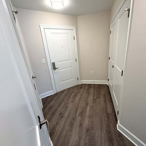 a room with a white door and a wooden floor.