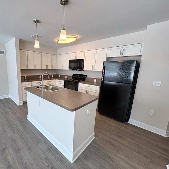 a kitchen with black appliances and white cabinets.