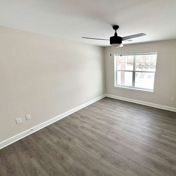 a room with a ceiling fan and a window.