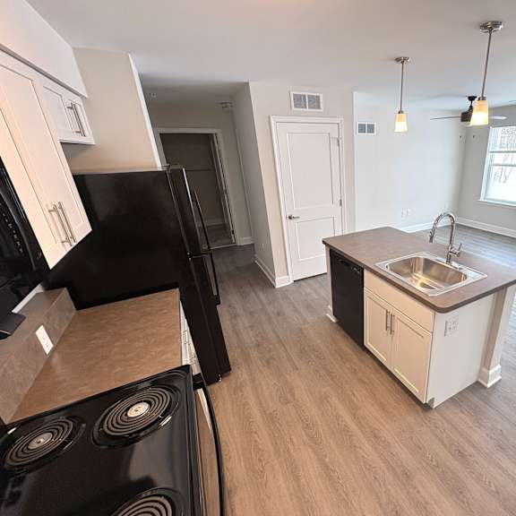a kitchen with a black stove top oven and a black refrigerator.