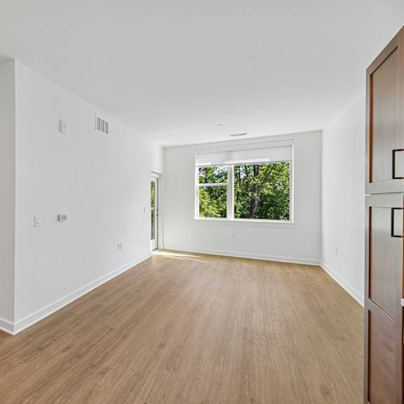 a room with white walls and wooden flooring.