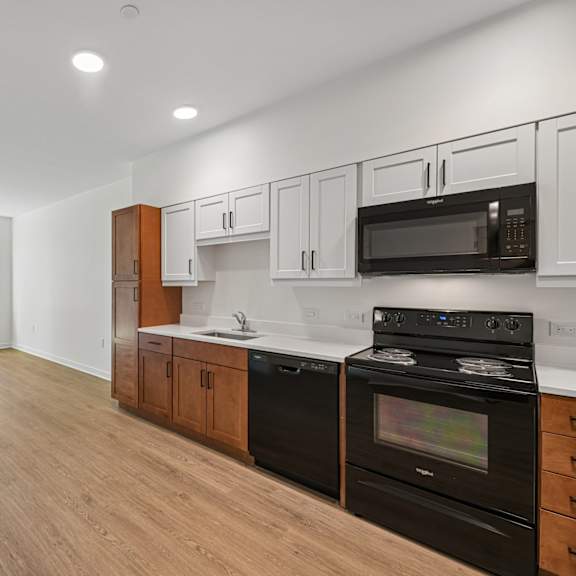 a kitchen with black appliances and wooden cabinets.