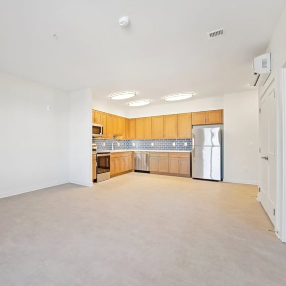 empty room with wooden cabinets and a refrigerator.