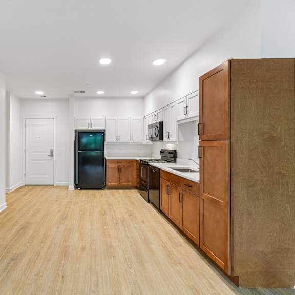 a kitchen with wooden floors and white walls.