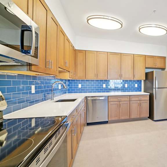 a kitchen with wooden cabinets and a blue tile backsplash.
