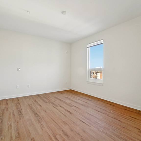 a room with wooden flooring and a window.