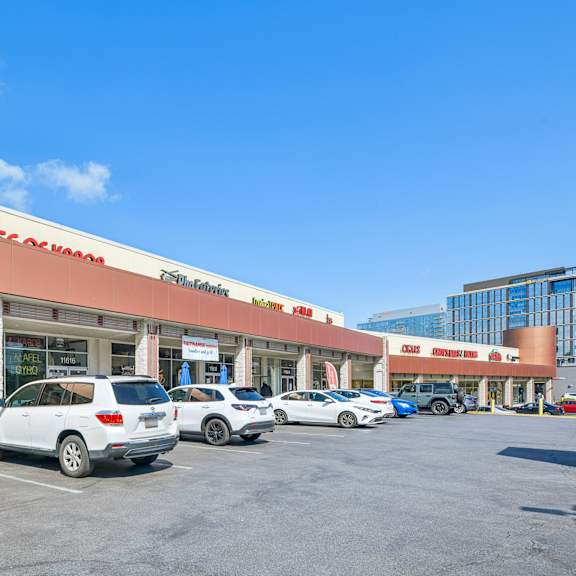 a row of cars are parked in front of a homegoods store.