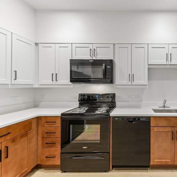 a kitchen with black appliances and wooden cabinets.
