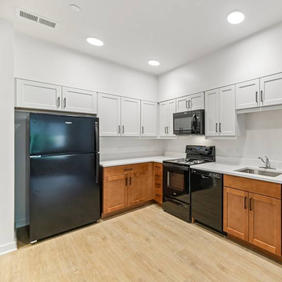 a kitchen with black appliances and wooden cabinets.