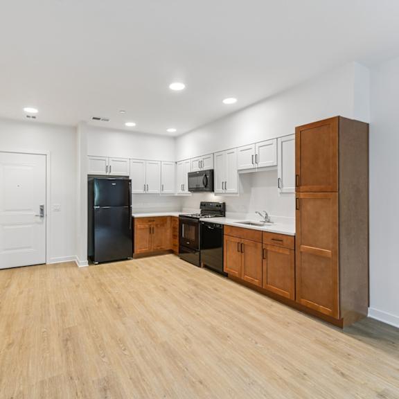 a kitchen with wooden floors and white walls.