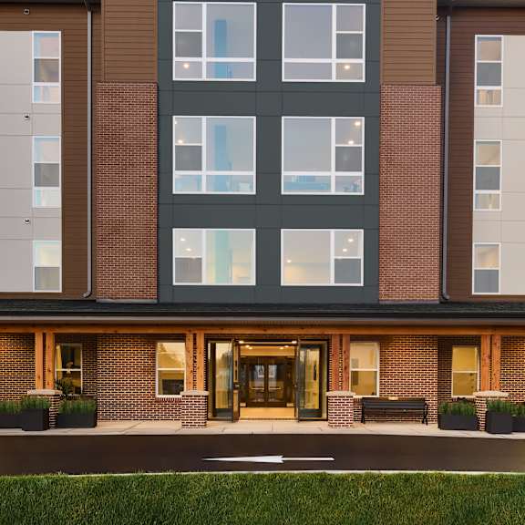a rendering of a brick building with large windows