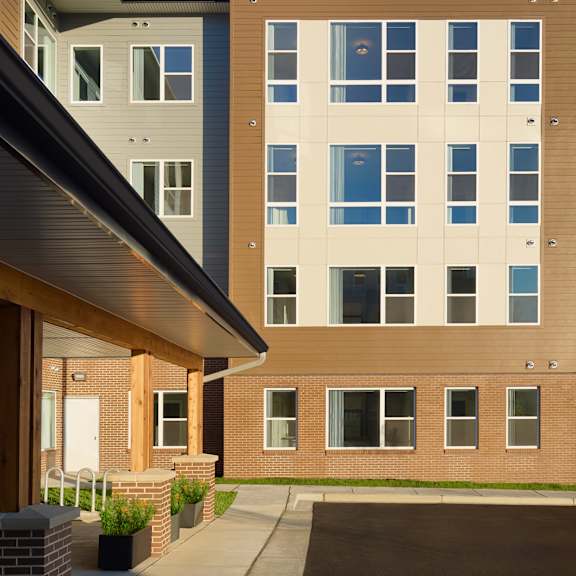 an exterior view of an apartment building with a sidewalk