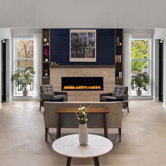 a living room with a fireplace and a table and chairs