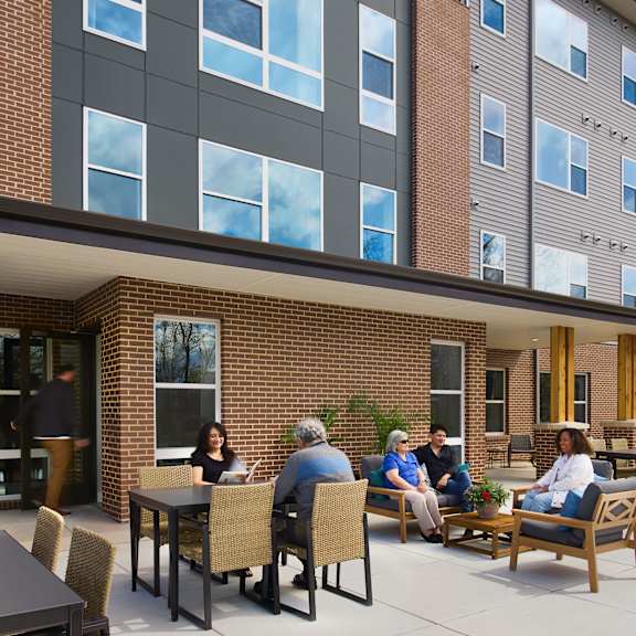 a group of people sitting at a table outside of a building