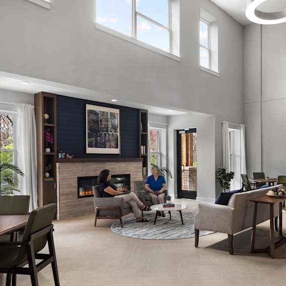 a rendering of a living room with a fireplace and people in it
