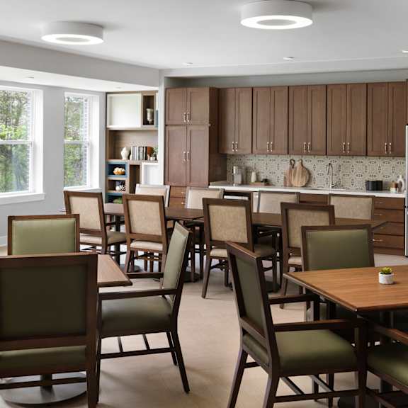 a large dining room with tables and chairs and a kitchen