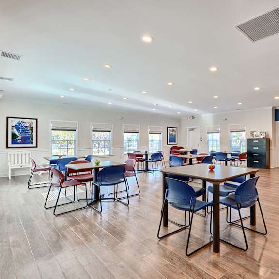 a dining room with tables and chairs and a kitchen