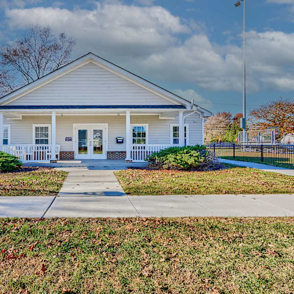 a white house with a sidewalk in front of it