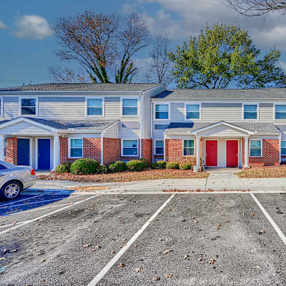 an empty parking lot in front of a building with a red door