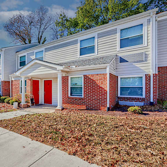 a red door on a brick house with a sidewalk