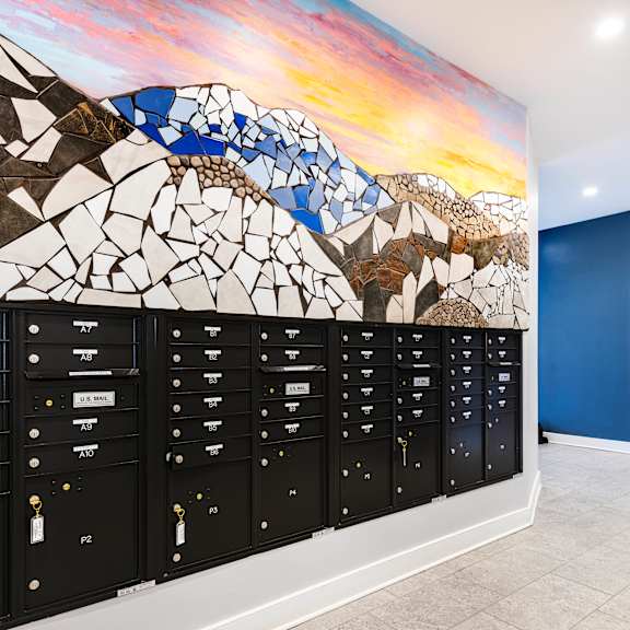 a mural of mountains and rocks is painted on the wall of a school hallway