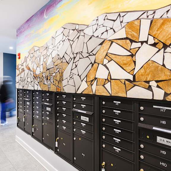 a painting of a rocky landscape hangs on the wall of a school hallway