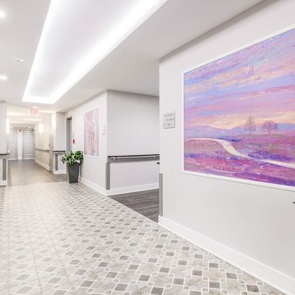 a hallway with a large painting on the wall