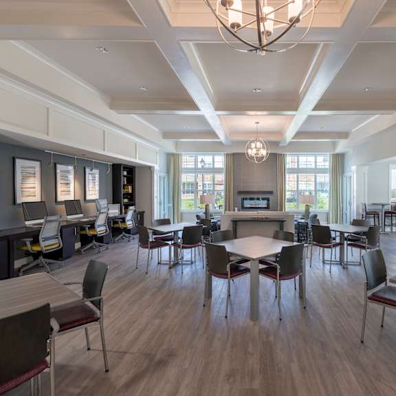 a large room with tables and chairs and a pool table in the background