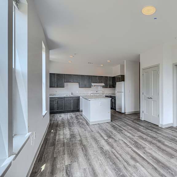a spacious kitchen with white cabinets and a large island.