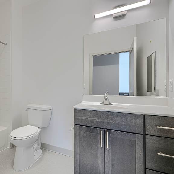 a white bathroom with a toilet, sink, and bathtub.