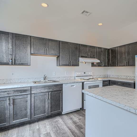 a kitchen with dark wood cabinets and white appliances.