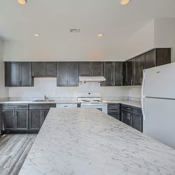 a kitchen with a white fridge and black cabinets.
