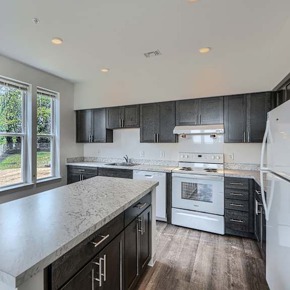 a kitchen with a marble countertop and stainless steel appliances.