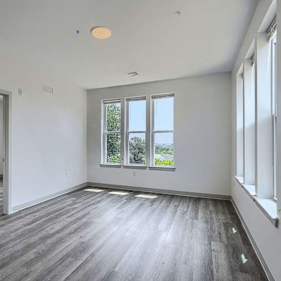 a large empty room with wooden floors and white walls.