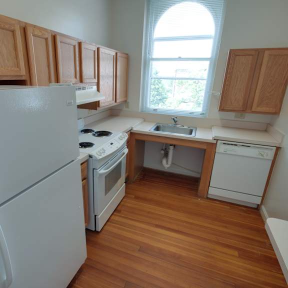 a kitchen with wooden cabinets and a white fridge.