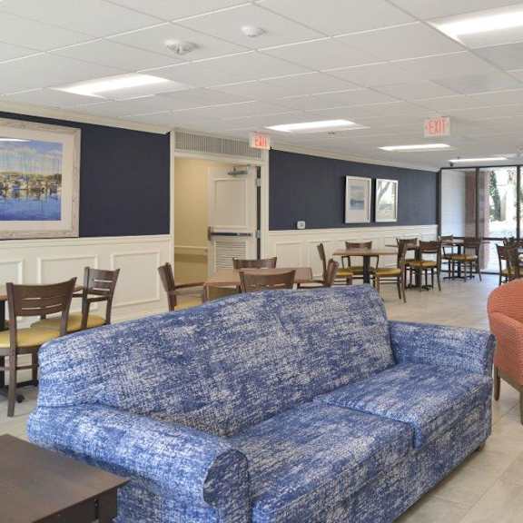 a room with a couch chairs and tables in it