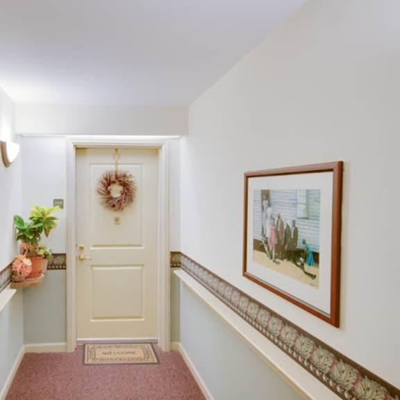 a hallway with a white door and pictures on the walls