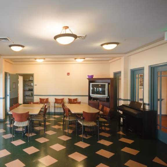 a dining room with tables and chairs and a piano