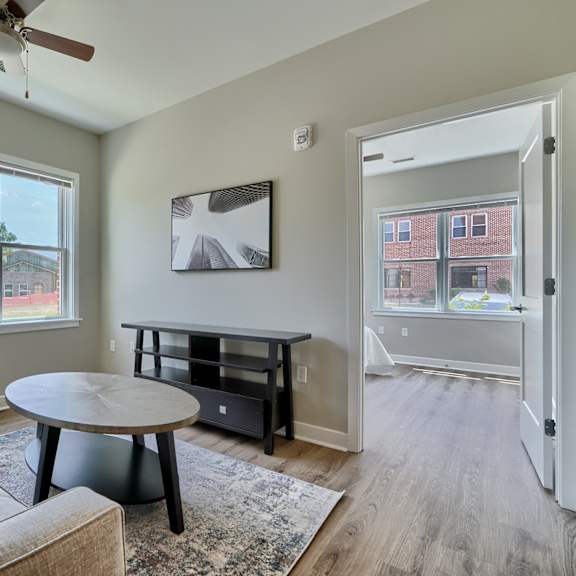 a living room with a couch, a coffee table, and a ceiling fan.