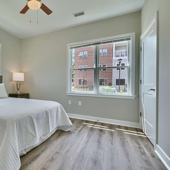 a bedroom with a large bed and a window overlooking a building.