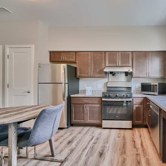 a kitchen with wooden cabinets and a grey chair.