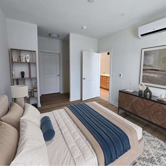 a bedroom with a bed, a couch, a chair, and a painting on the wall.