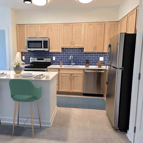 a kitchen with a white counter and green chairs.