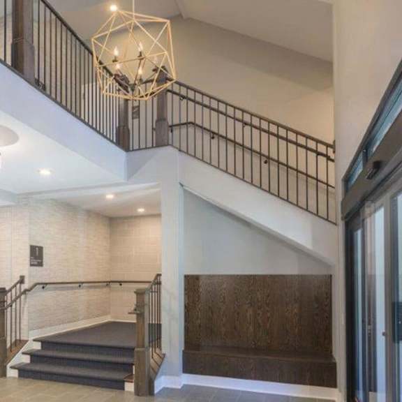a staircase with a metal railing and a glass door.
