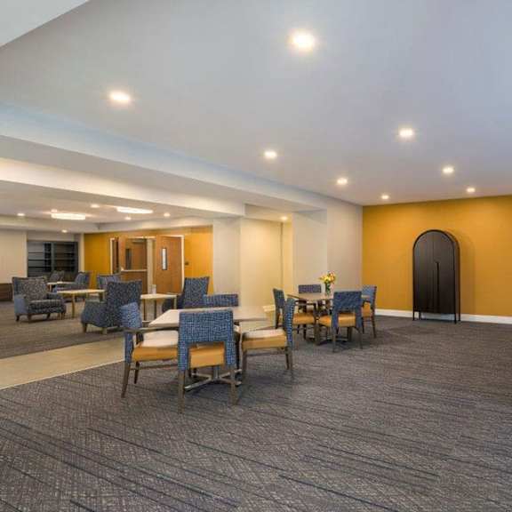 a room with a pool table and chairs.