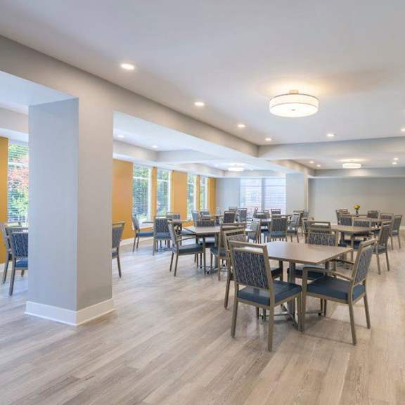 a spacious dining room with a large table and chairs.