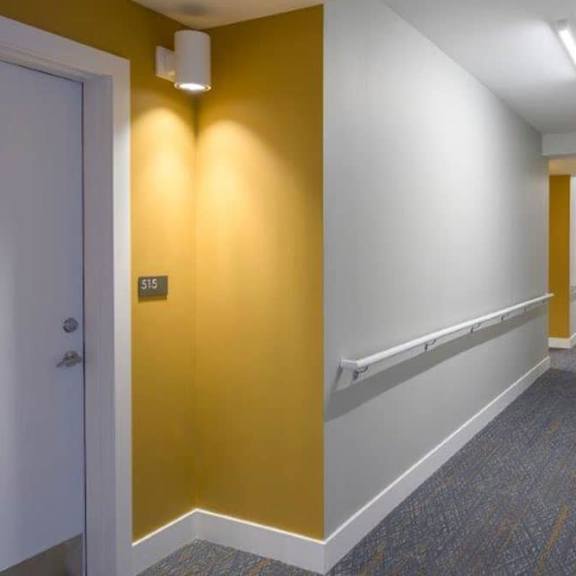 a long hallway with a carpeted floor and white walls.