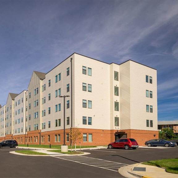 a modern building with a parking lot in front.
