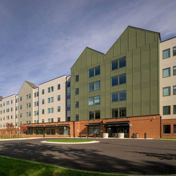 a modern building with a mix of green and beige colored panels.