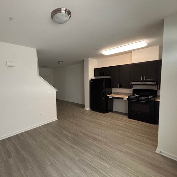 a kitchen area with a stove top oven and a refrigerator.